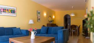 内尔哈梅纳广场酒店的客厅配有蓝色的沙发和桌子