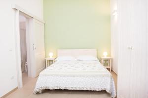 GuagnanoNonna Nina的白色卧室配有白色床和2张桌子