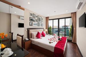 河内金月亮套房酒店 的一间卧室配有一张带红色枕头的床
