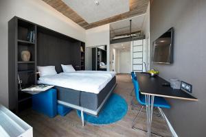 Nærum起居套房公寓式酒店的一间卧室配有一张床、一张桌子、一张床和一张桌子