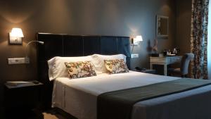 马德里Hotel Moderno Puerta del Sol的一间卧室配有一张大床和两个枕头