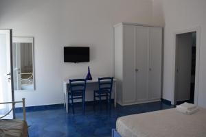 普罗奇达西罗度假屋的一间卧室配有桌椅和电视