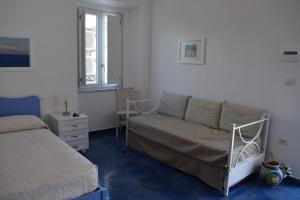 普罗奇达西罗度假屋的一间带沙发、床和窗户的卧室