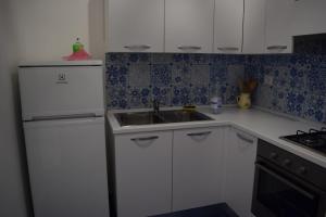 普罗奇达西罗度假屋的厨房配有白色橱柜和水槽