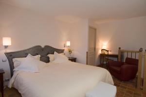 芒德法兰西酒店的卧室配有一张白色大床和一把椅子