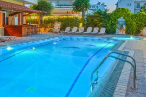 科斯镇帕夫洛斯酒店的一座带椅子的大型蓝色游泳池