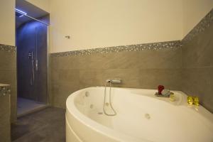 卢卡安娜别墅住宿加早餐酒店的带淋浴的浴室配有白色浴缸。