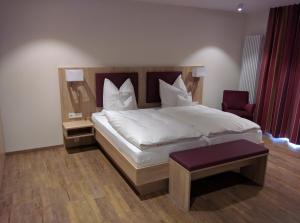 NeuenradeHotel Zur-Borke的卧室配有一张白色大床和一把椅子