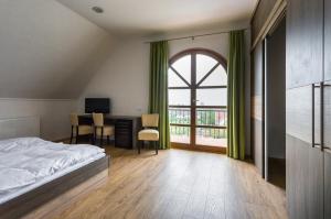 巴拉顿菲赖德费古拉文德加兹旅馆的一间卧室配有一张床、一张书桌和一个窗户。