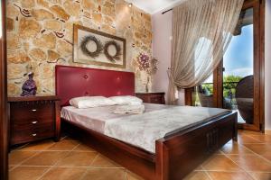 佩科霍里Villa Pefkohori的一间卧室设有一张床和石墙