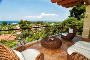 佩科霍里Villa Pefkohori的阳台配有藤椅,享有海景。