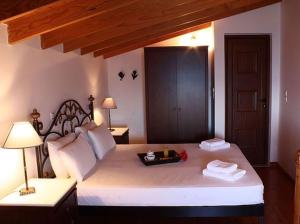 斯卡拉Kekrifalia Hotel的卧室配有一张白色大床和木制床头板