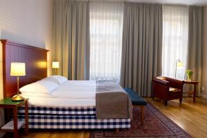 雪平雪平比谢普斯阿姆斯酒店的配有一张床和一把椅子的酒店客房