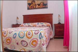 科尼尔-德拉弗龙特拉Apartamento Pascual Junquera I的一间卧室配有一张带五颜六色棉被的床