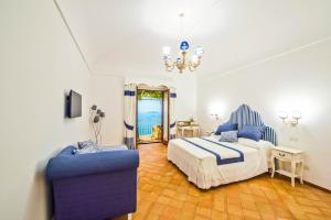 波西塔诺五家公寓酒店的一间卧室配有一张床和一张蓝色椅子