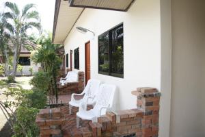 甲米镇Forum House Hotel Krabi的砖墙上带白色椅子的庭院