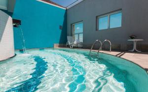 圣保罗特朗萨麦利卡行政酒店的一座带蓝色墙壁的大型游泳池