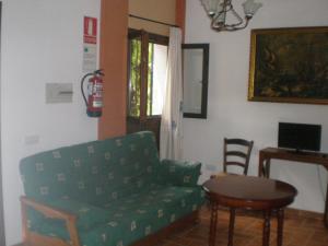 CarcabueyApartamentos Rurales El Cañuelo de Carcabuey的客厅配有绿色沙发和桌子