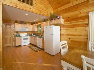 赛维尔维尔A Slice of Heaven Holiday home的厨房配有白色冰箱和木墙