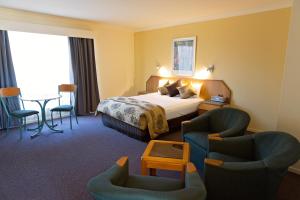 麦凯怀特蕾丝汽车旅馆的酒店客房,配有一张床和两把椅子