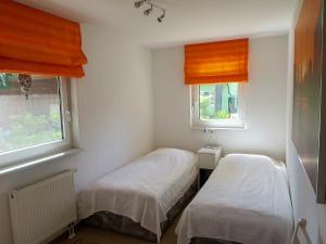 朗斯多夫Ferienhaus Schillo的带2扇窗户的小客房内的2张床