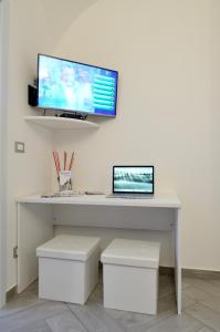 泰尔莫利La Casetta di Mary的一张桌子,上面有笔记本电脑和墙上的显示器