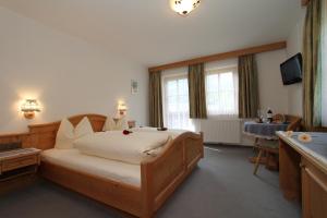 罗孚尔Hotel - Wirts'haus "Zum Schweizer"的一间卧室配有一张大床和电视