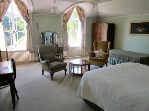 埃姆斯沃思Hollybank House的一间卧室配有一张床铺、椅子和一张桌子