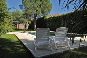 圣拉斐尔Chalet San Rafael的两把白色椅子坐在游泳池旁