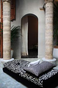 拉巴特阿尔卡萨酒店的一张黑白的睡床,位于一个有两根柱子的房间