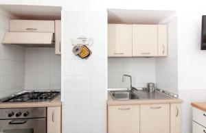 奥斯图尼Micca House的厨房配有白色橱柜和水槽