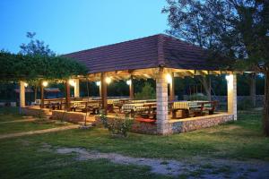 Drinovci科尔卡加里克农业旅游旅馆的公园的凉亭,晚上有桌子和长椅