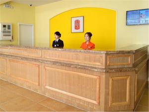 天津如家快捷酒店天津围堤道市文化中心店的两名妇女站在等候室的接待台
