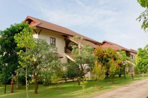 清莱Teak Garden Resort, Chiang Rai的前面有大量树木的建筑