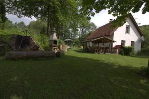 Kladenské Rovné奥瑞兹之家山林小屋的一座大型白色房子,庭院里放着木柴