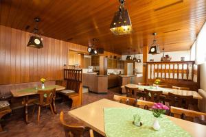 HausenZur Dorfschänke的餐厅设有木墙和桌子,还设有厨房