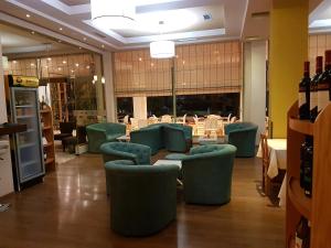 萨兰达考尼亚酒店的一间餐厅,房间内设有绿色的椅子和桌子
