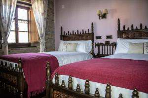 福斯Alén do Mis - Hotel Rural的卧室内的两张床,配有紫色床单