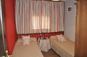 佩德拉萨Casa Rural Pedraza的客房设有两张床和窗户。