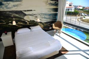 阿尔热祖尔HI Arrifana Destination Hostel的一间卧室配有一张床,享有海景