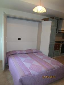 Roncegno黛博拉公寓的一间卧室,在房间内配有一张紫色的床