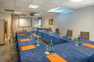 班纳萨克Hôtel-Restaurant Le Calice Du Gevaudan - A75的会议室配有带绿瓶的蓝色桌子