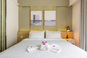 甲米镇Snoozz Hotel Krabi的卧室配有白色床和毛巾