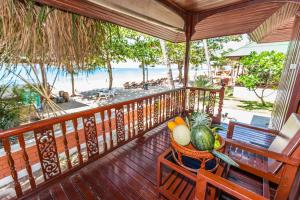 拉迈拉迈椰子海滩度假村的阳台配有带水果和蔬菜的桌子。