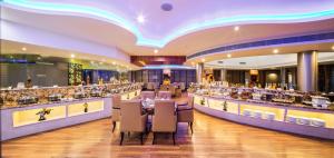 德瓦纳哈利-班加罗尔克拉克异国Spa情调度假酒店的餐厅设有配备了桌椅的长酒吧