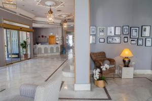 赫雷斯-德拉弗龙特拉多尼亚布兰卡酒店的大堂设有椅子和墙上的照片