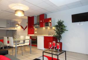 圣托·蒂尔索Equinaturi的一间厨房和带红色橱柜及桌子的用餐室