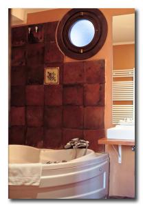 雷克纳多纳安妮塔酒店及餐厅的带浴缸的浴室和窗户。