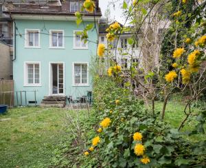 温特图尔EMMA Bett und Bistro的院子里的蓝色房子,花黄色