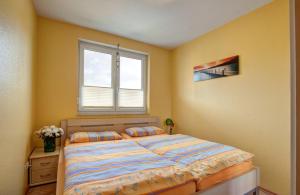 于克里茨Wohnung 4 Am Sportplatz Ückeritz的一间卧室设有一张床和一个窗口